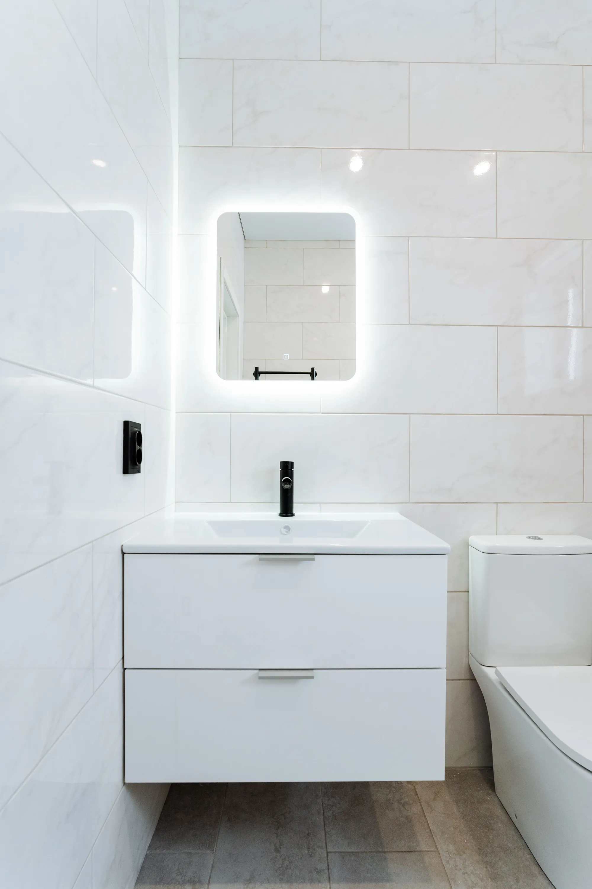 Bathroom vanity with a framed mirror and tiled walls