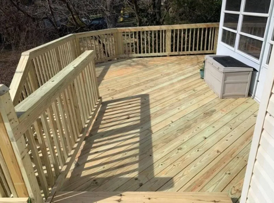 Raised wood deck with a matching wood railing and a stair run at the corner