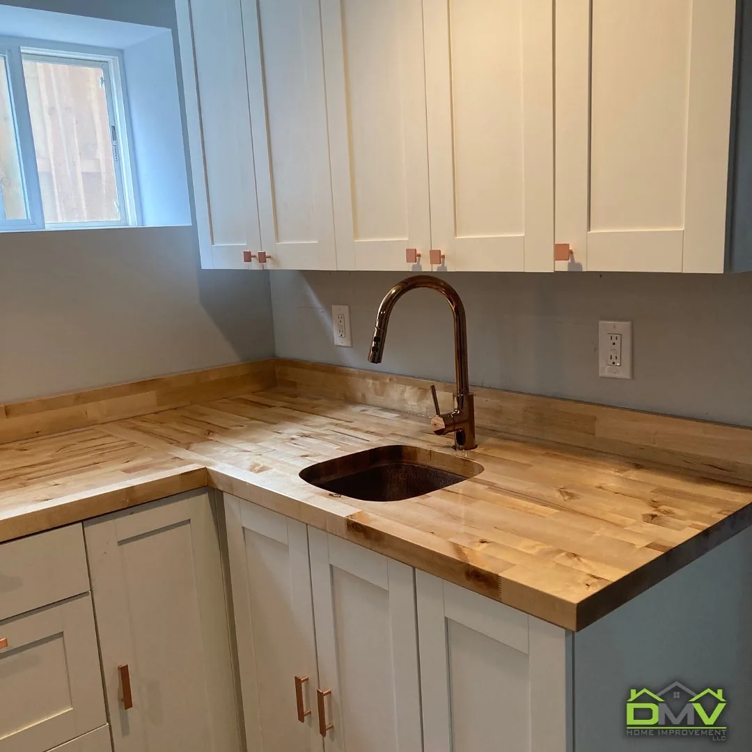 Kitchen corner with white shaker cabinets and a butcher block countertop