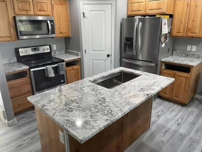 Kitchen remodel with granite island, wood cabinetry, and stainless steel appliances